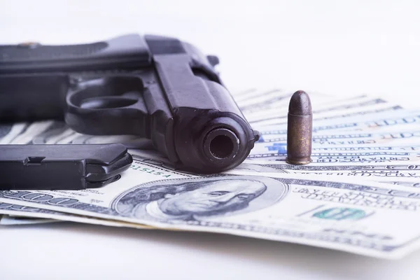 Gun with bullet on US dollar banknotes.