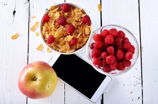 Healthy eating, cereals, apple and raspberries on a white wooden