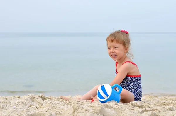 Summer Photo - charming girl playing on a sandy beach, space for