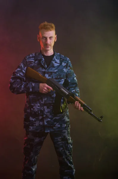 Man in camouflage clothing with a gun