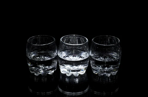 Three glasses of liquor, isolated on a black background