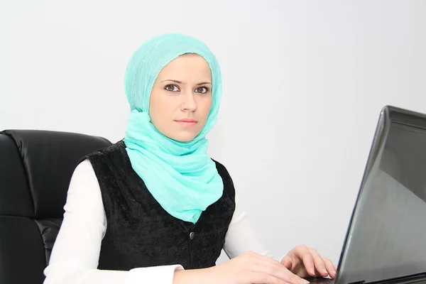 Beautiful young muslim business woman with laptop in office