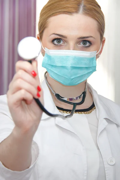 Young female doctor with mask and stethoscope