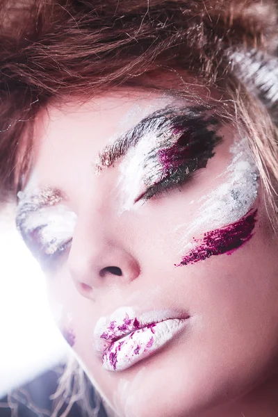 Studio portrait of beautiful woman with creative make-up