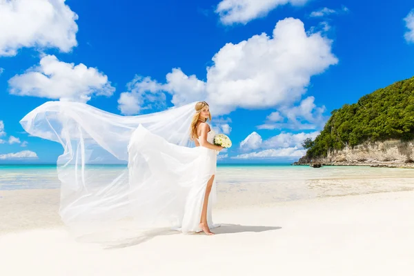 Beautiful blond bride in white wedding dress with big long white