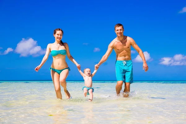 Happy family, mom, dad and little child having fun on a tropical