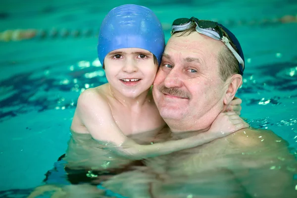 Grandfather with boy in pool
