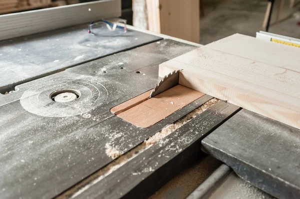 Industrial tool in wood factory, circular blade with a wood board.