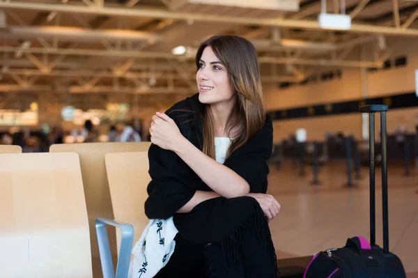 Airport Young female passenger at gate waiting in terminal while waiting for her flight.