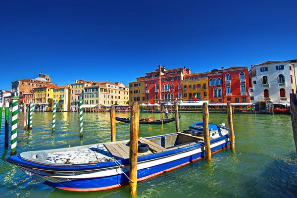 Venice boat colored houses, wooden poles,