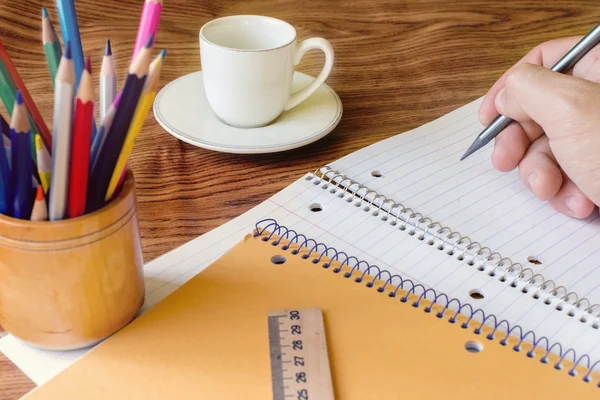 Pencils and notebooks, coffee cup,  hand writing, pencil, deskto