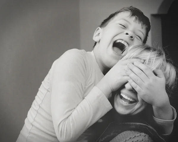 Son mom closes eyes hands laughing black and white