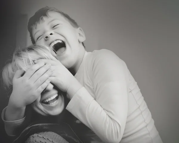 Son mom closes eyes hands laughing black and white