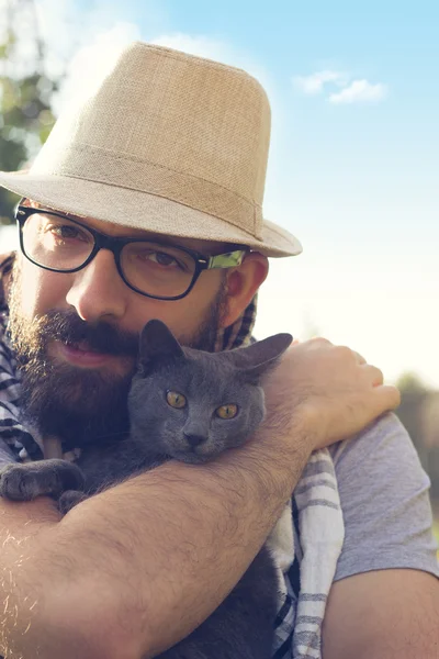Hipster guy playing with his cat