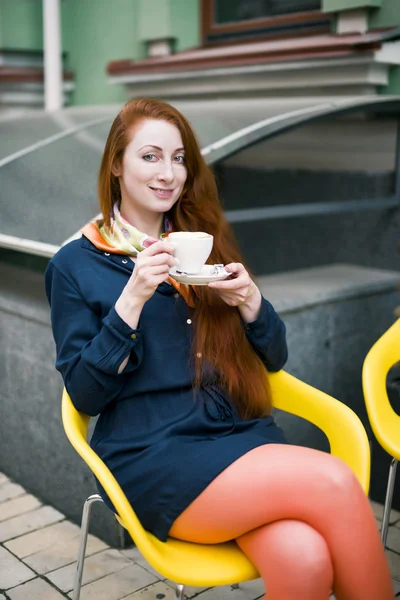 Ginger woman with coffee cup.