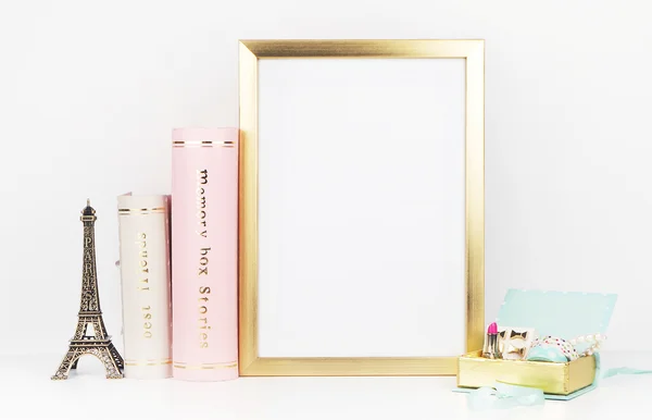 Gold picture frame with decorations. Mock up for your photo or text Place your work, print art,shabby style, white background,, pastel color book, paris, lipstick, mint and gold accessories