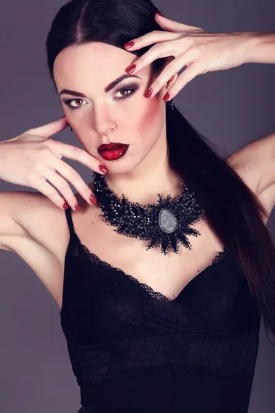 Beautiful woman with dark hair and evening makeup. Jewelry and Beauty. Fashion art photo