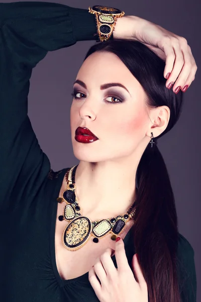 Beautiful woman with dark hair and evening makeup. Jewelry and Beauty. Fashion art photo