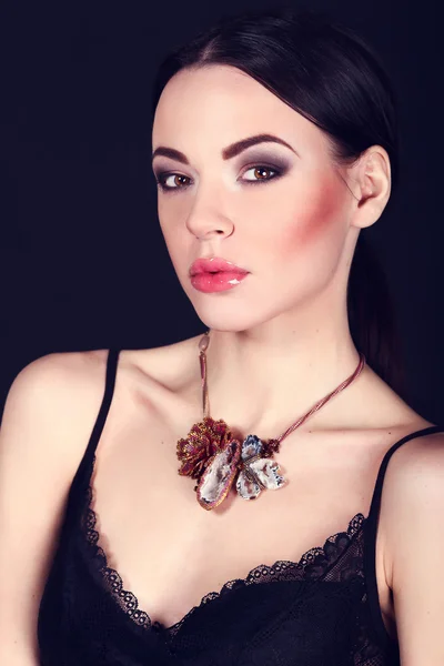 Beautiful woman with dark hair and evening makeup. Jewelry and Beauty. Fashion art photo