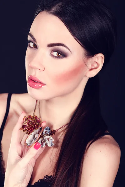 Beautiful woman with dark hair and evening makeup. Jewelry and Beauty. Fashion art photo