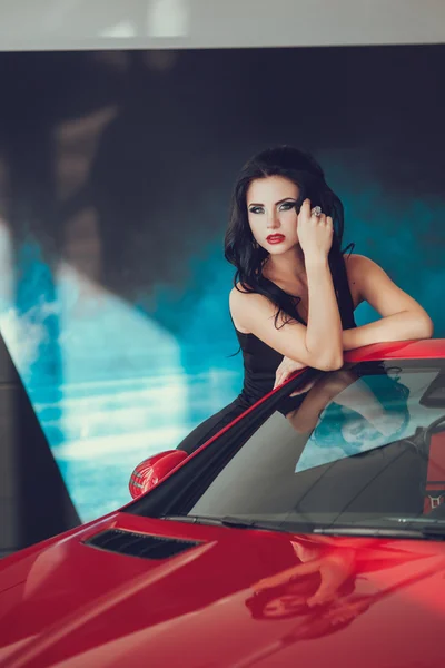 Close up portrait of Young pretty brunette lady with a modern luxury car