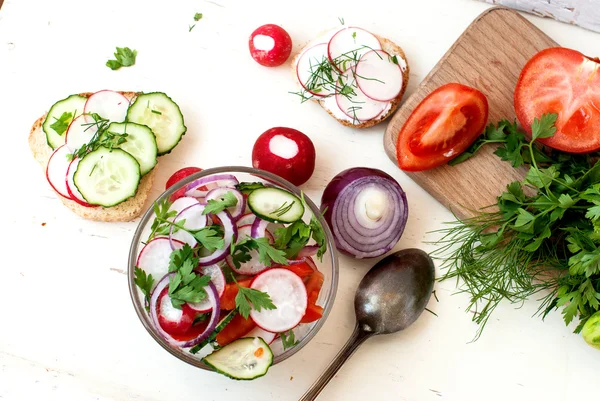 Spring salad with radishes, cucumber, cabbage and onion close-up