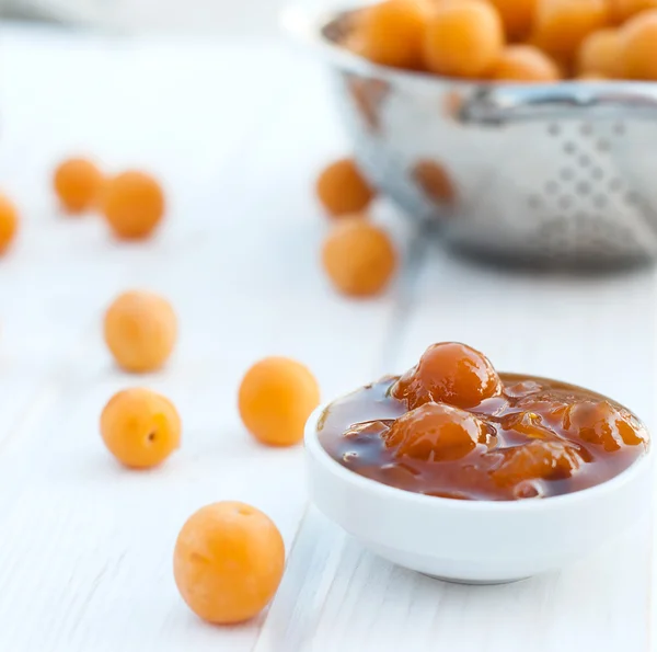 Homemade jam of yellow plum on a white board