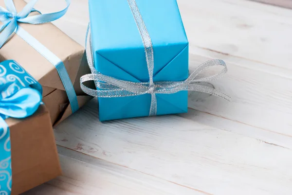 Boxes with gifts decorated with ribbons on a white wooden backgr