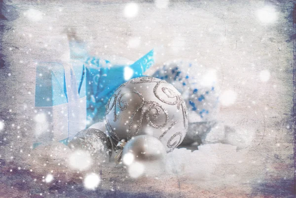 Silver Christmas balls and gifts on wooden table