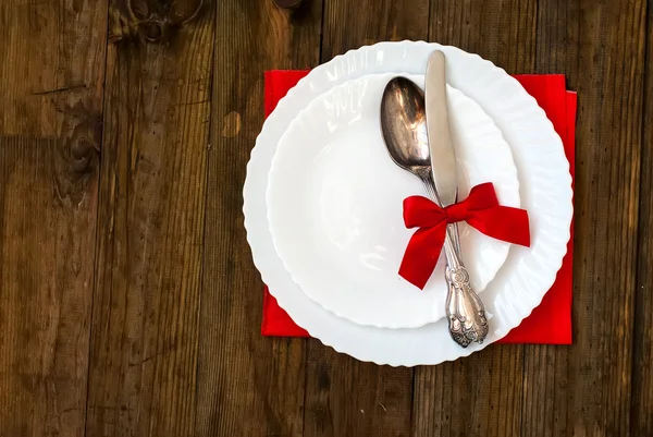 Serving holiday table, spoon, fork, knife, white plates on a woo
