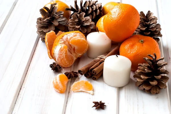 Tangerines, cinnamon sticks, star anise and candle