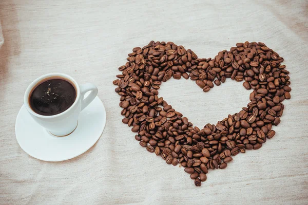 Cup of Coffee. roasted beans in heart shape . isolated on white background.