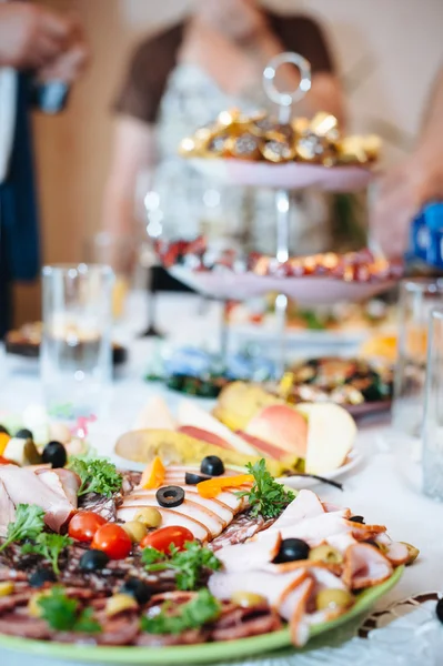 Table with food and drink. Catering table set service with silverware and glass stemware at restaurant before party