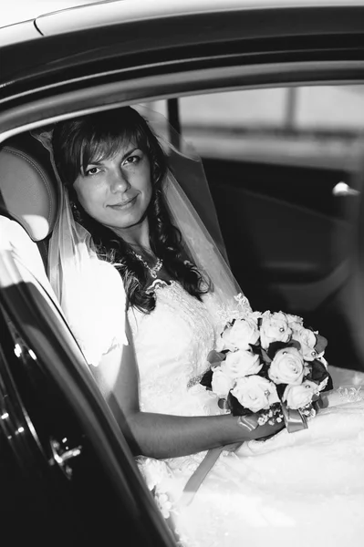Close-up portrait of pretty shy bride in a car window