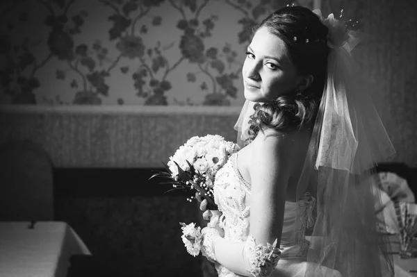 Portrait beautiful bride with bouquet of flowers on luxury interior in wedding day