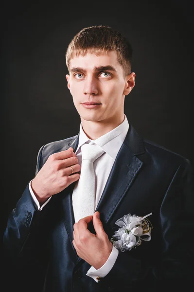 Hands of wedding groom getting ready in suit. black studio background