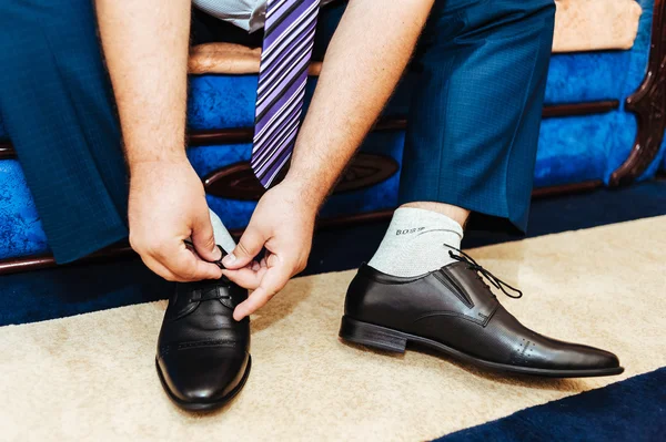 Best man getting ready for a special day. groom putting his wedding shoes.