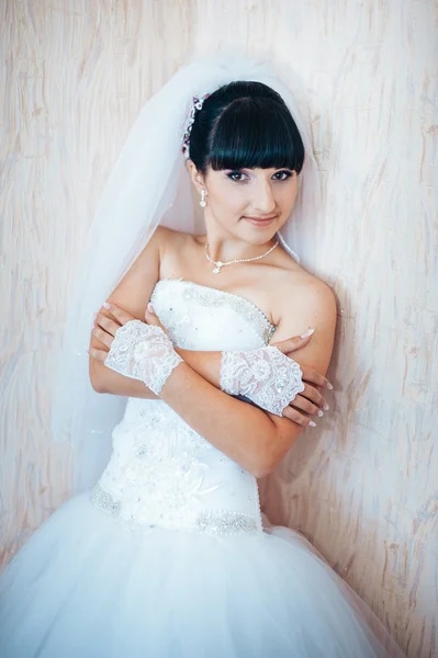 Beautiful bride getting ready in white wedding dress with hairstyle and bright makeup. Happy sexy girl waiting for groom. Romantic lady in bridal dress have final preparation for wedding.