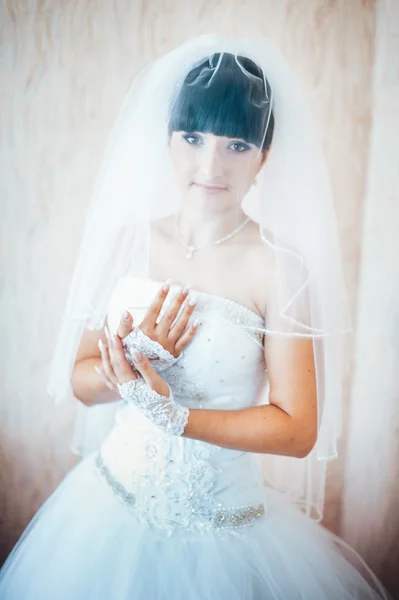 Beautiful bride getting ready in white wedding dress with hairstyle and bright makeup. Happy sexy girl waiting for groom. Romantic lady in bridal dress have final preparation for wedding.