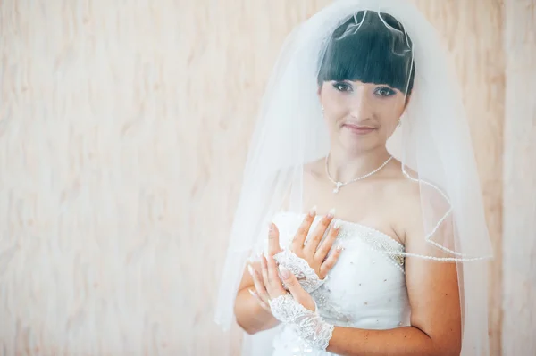 Beautiful bride getting ready in white wedding dress with hairstyle and bright makeup. Happy sexy girl waiting for groom. Romantic lady in bridal dress have final preparation for wedding.