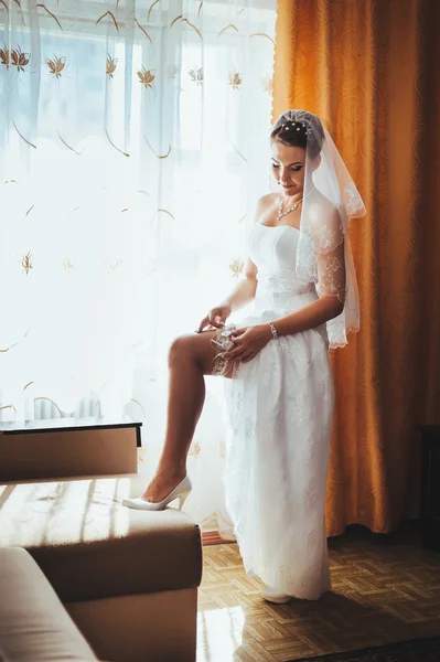 Bride getting ready. beautiful bride in white wedding dress with hairstyle and bright makeup. Happy sexy girl waiting for groom. Romantic lady in bridal dress have final preparation for wedding