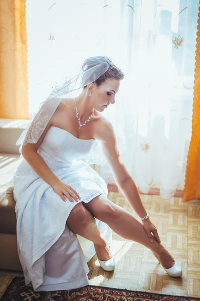 Bride getting ready. beautiful bride in white wedding dress with hairstyle and bright makeup. Happy sexy girl waiting for groom. Romantic lady in bridal dress have final preparation for wedding