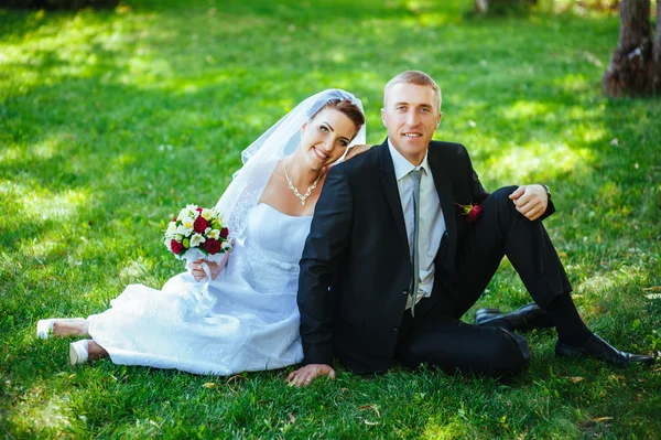 Bride and Groom at wedding Day walking Outdoors on spring nature. Bridal couple, Happy Newlywed woman and man embracing in green park. Loving wedding couple outdoor.