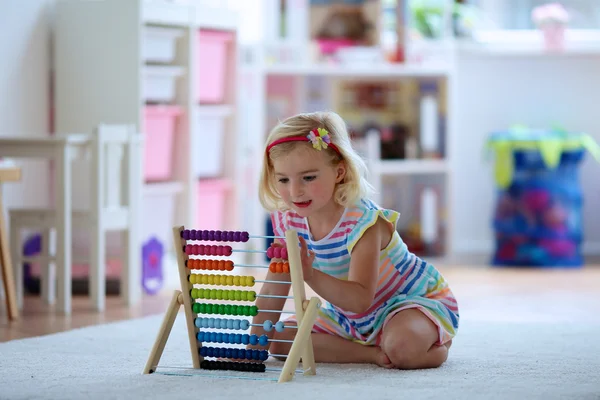 Happy toddler girl playing with abacus