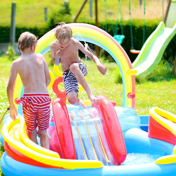 Kids splashing in inflatable swimming pool