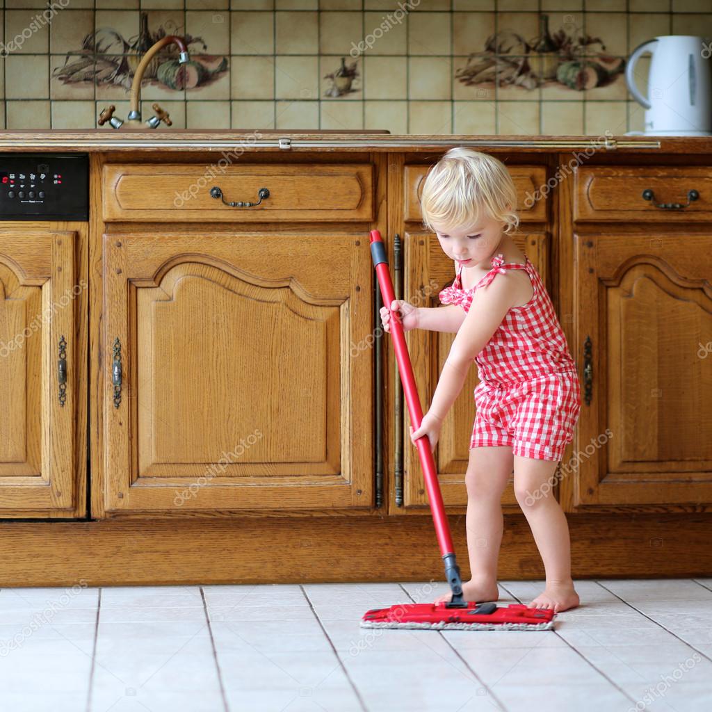 Mooie peuter meisje dweilen de vloer in de keuken — stockfoto ...