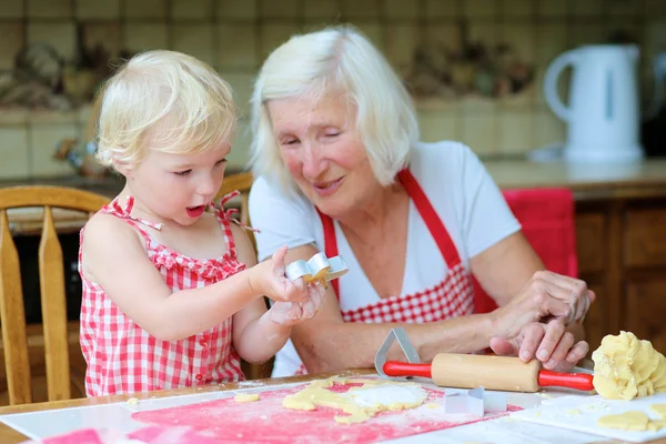 Grandmother making cookies with her granddaughter