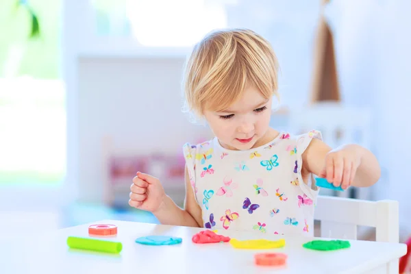 Toddler girl creating with play dough