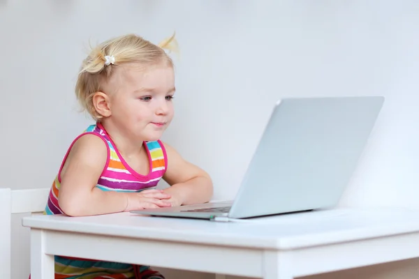 Little girl playing with laptop