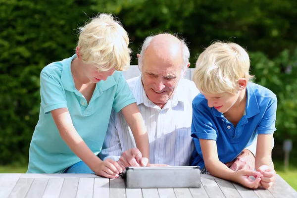 Grandkids teaching grandpa to use tablet pc